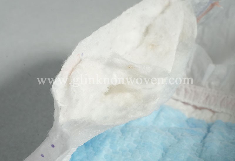 What is the role of the nonwoven wrapping fabric in diapers?